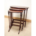 A nest of three oval mahogany tables on fine turned legs