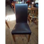 A set of 8 black faux leather upholstered dining chairs