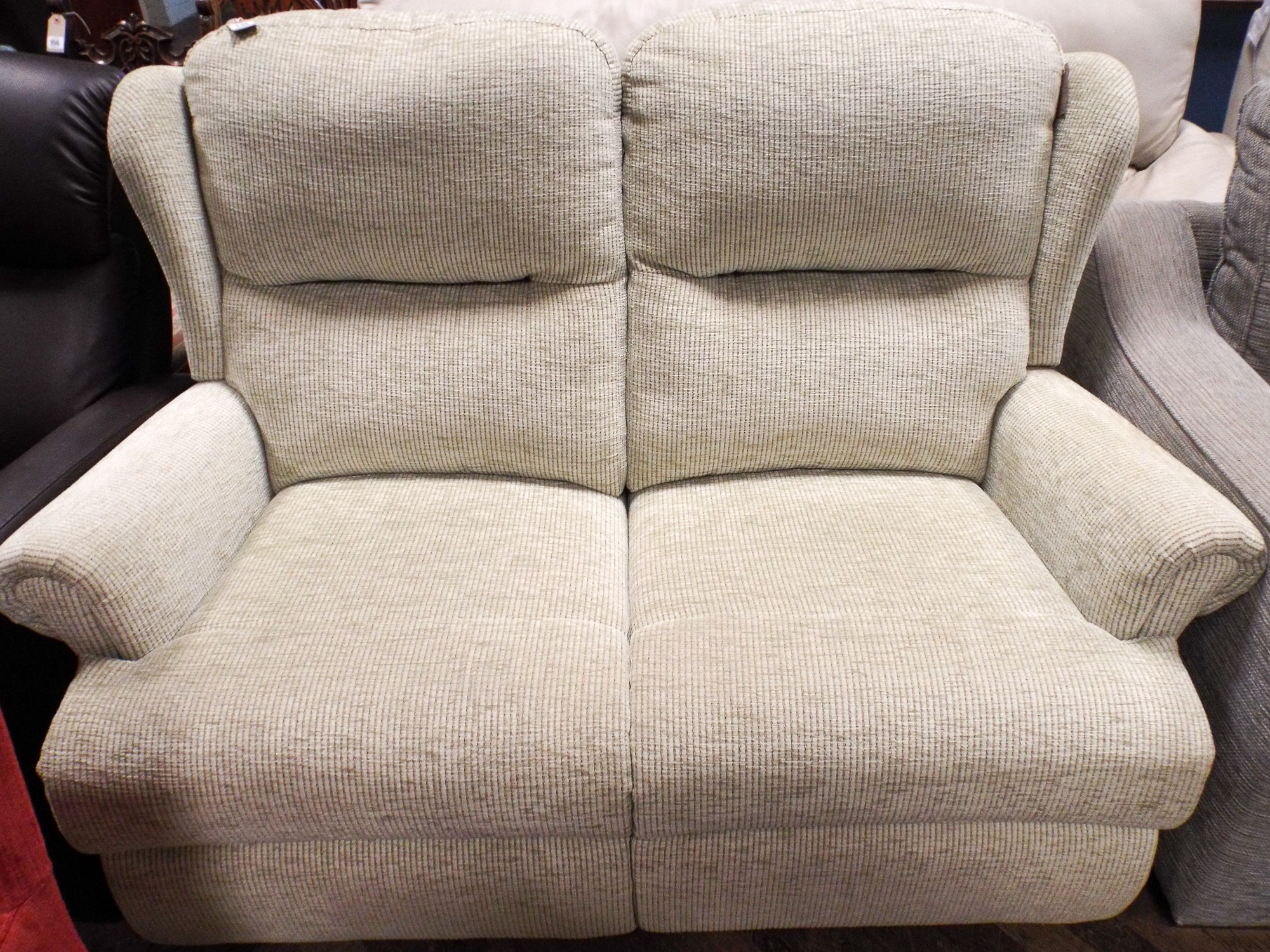 A modern two reclining seater settee in pale green mottled material