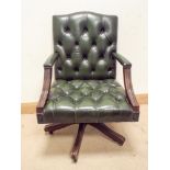 A mahogany framed antique green buttoned leather, spring framed swivel,