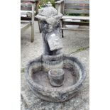 A reconstituted stone garden ornament of an old water pump with trough