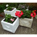 Four white painted reconstituted stone square garden planters each containing plants