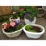 Two circular white painted reconstituted stone garden planters and two oval garden planters all