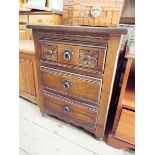 A carved oak bedside cabinet fitted three drawers