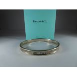 Tiffany & Co silver bangle together with a pair of silver heart shaped stud earrings marked Tiffany