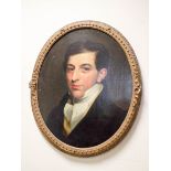 An early 19th Century oil on canvas portrait of a Regency gentleman in an oval gilt frame