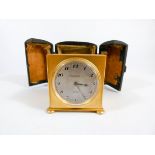 A Zenith 8 day travel clock in square gilt metal case,