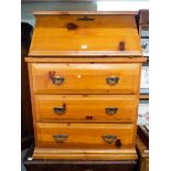 A varnished pine bureau fitted with three drawers