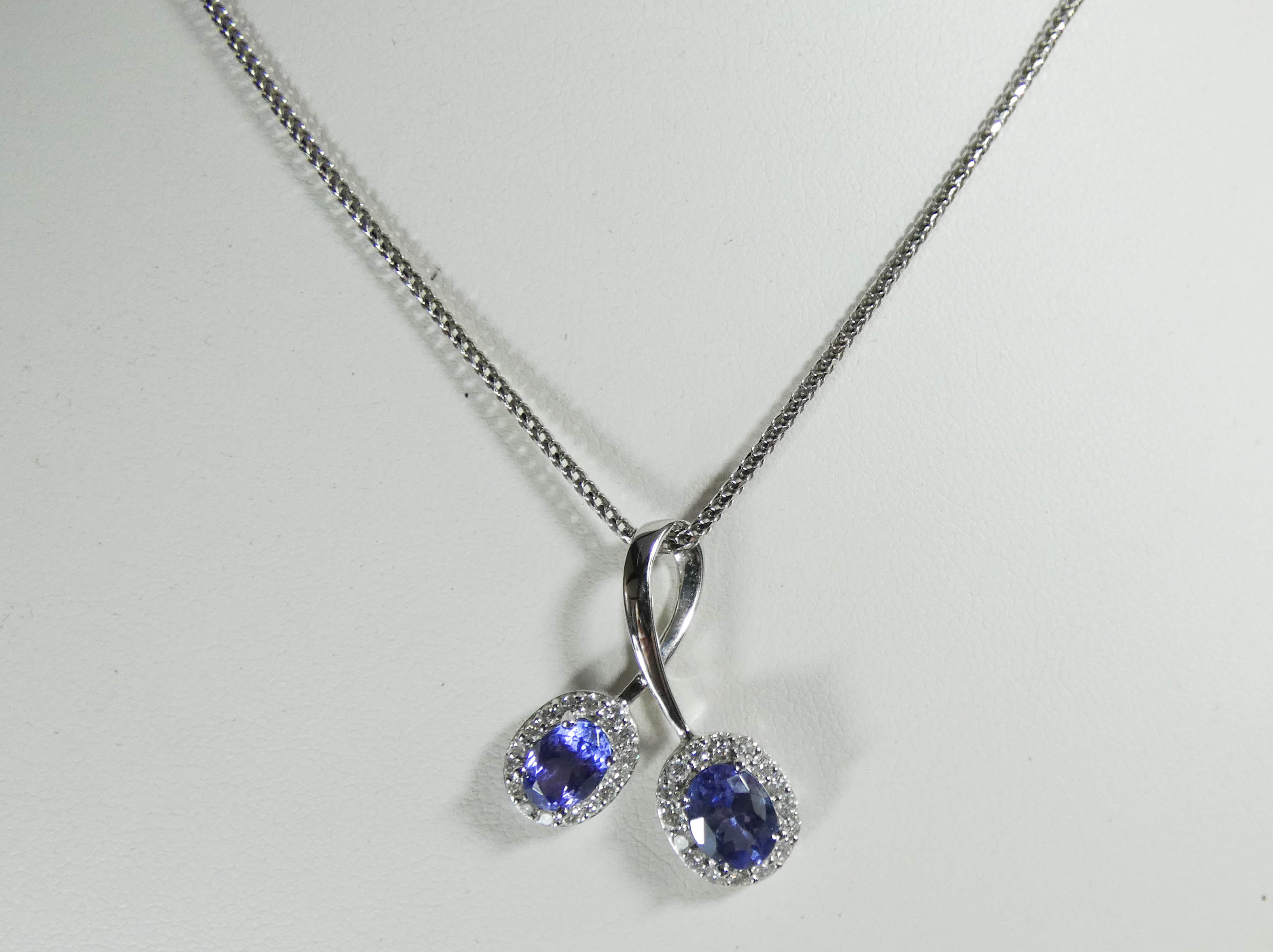 Modern 18ct white gold tanzanite and diamond cluster cross over design pendent on bright cut link - Image 2 of 4