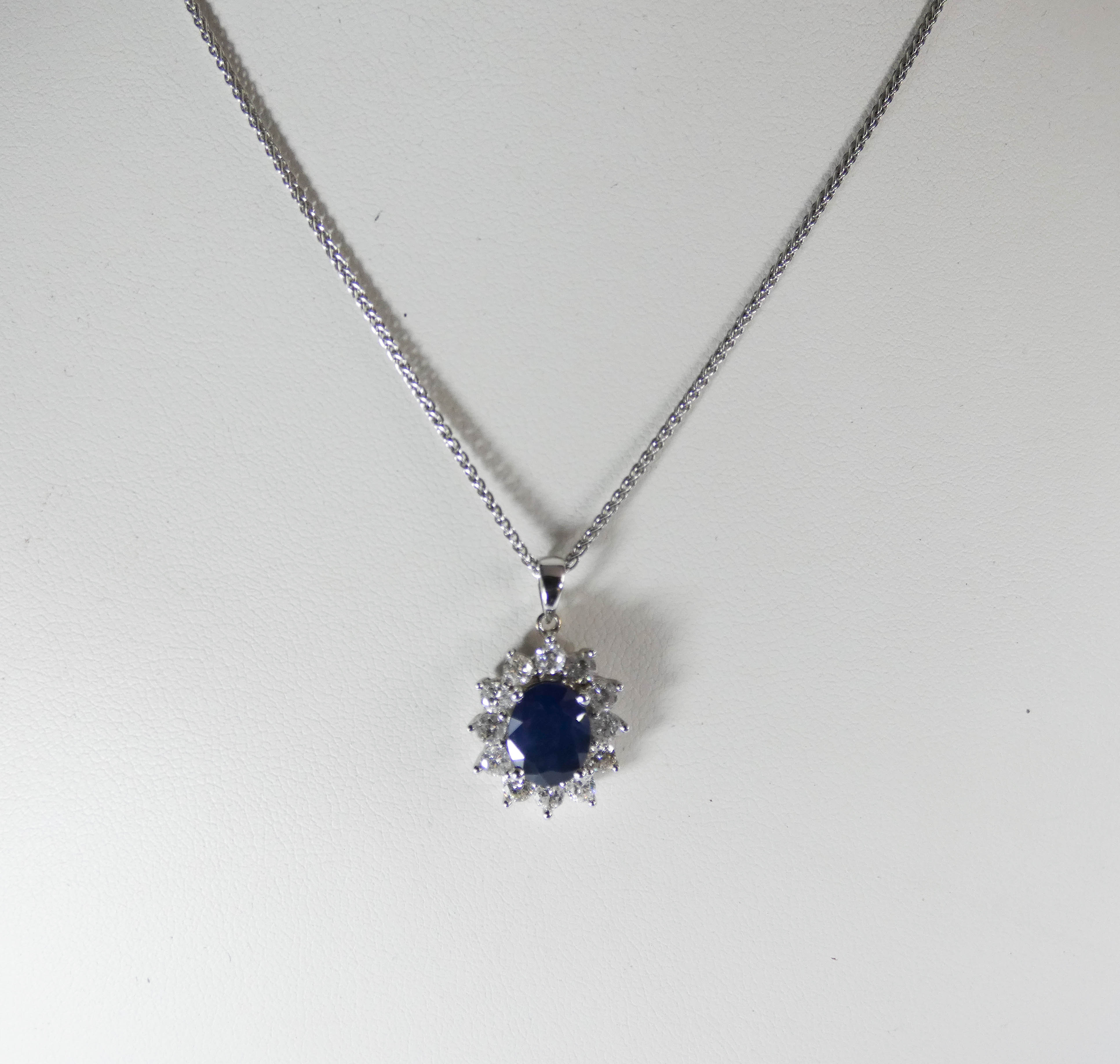 An 18ct white gold sapphire and diamond cluster pendent set with an oval sapphire surrounded by 12 - Image 2 of 3