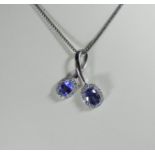 Modern 18ct white gold tanzanite and diamond cluster cross over design pendent on bright cut link