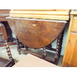 An oval oak gate legged table on barley twist legs,