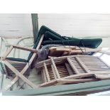 A collection of folding hardwood patio chairs with green cushions