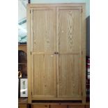 A nearly new modern light oak two door wardrobe