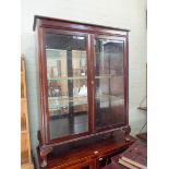 A mahogany, two door, glazed bookcase standing on cabriole feel,