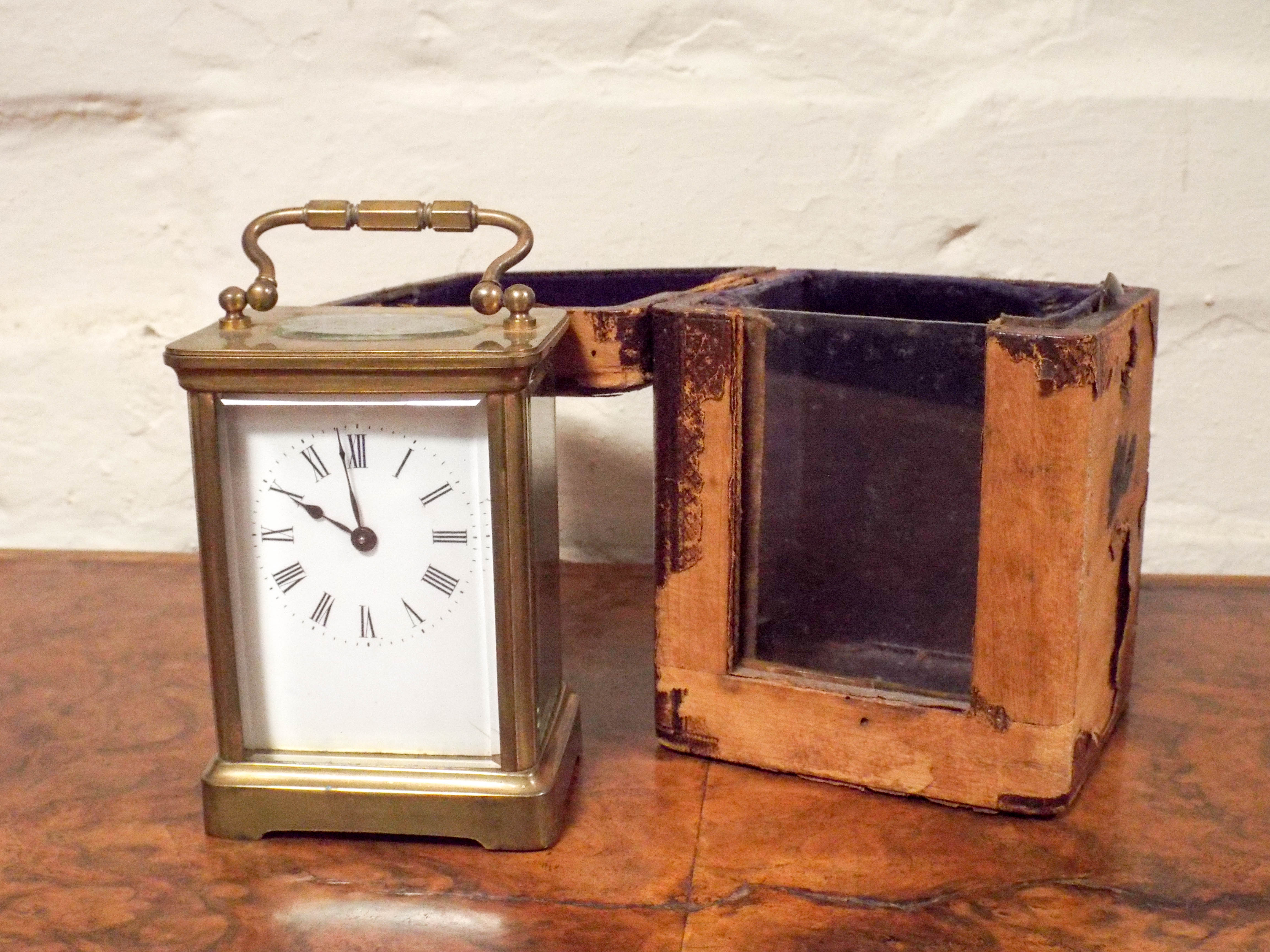 A gilt brass carriage clock in a leather travelling case with a key