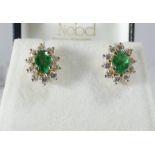A pair of 14ct yellow gold emerald and diamond cluster ear studs each set with an oval emerald