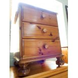 A modern varnished pine tall boy chest of five drawers and a three drawer bedside cabinet