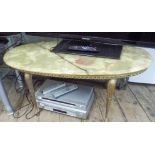 An oval onyx topped coffee table on gilt metal legs