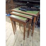 A nest of three reproduction mahogany coffee tables with inset leather and glass tops