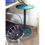 A metal sun dial on a metal base and four assorted hanging flower baskets