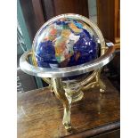 A Gemstone set globe of the world on brass stand