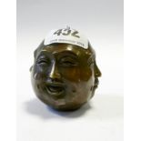 A small brass four sided Buddha head paperweight