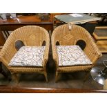 A pair of tub shaped wicker conservatory armchairs with cushions