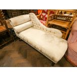 A small chaise longue upholstered in cream patterned material