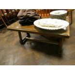 A plank top coffee table on turned legs and stretcher base with glass top