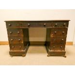 A Victorian mahogany kneehole pedestal desk fitted nine drawers with leatherette top in need of