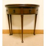 A Georgian style D shaped mahogany fold over top tea table fitted drawers standing on taper legs