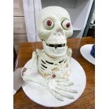 A painted iron skeleton money box