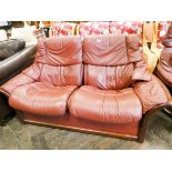 An Ekornes Stressless two seater settee in red leather with one matching reclining swivel chair and