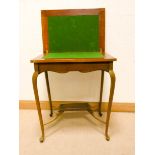 An Edwardian faded mahogany fold over top card table on cabriole style legs with under tier,
