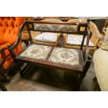 A small wood framed two seater hall settee with tapestry upholstered seats and back