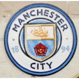 A circular cast iron wall hanging Manchester City plaque