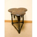 A late Victorian carved oak shamrock shaped occasional table on turned legs with cross stretchers
