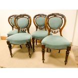 A set of four Victorian walnut dining room chairs on turned legs with oval upholstered panel back