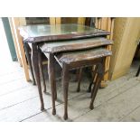 A nest of three reproduction mahogany coffee tables with inset glass and green leather tops