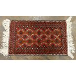 A small red and patterned Bokhara style rug 4' x 2'6