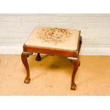 A Chippendale style mahogany dressing stool with tapestry top standing on cabriole legs with claw