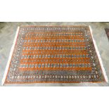 A terracotta Bokhara style wool pile rug approx 8'6 x 6'3