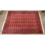 A large red and patterned Bokhara style rug 9'6 x 6'6