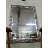 A large bevelled wall mirror in silver mottled frame