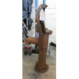 A large cast iron rusty garden pump ornament