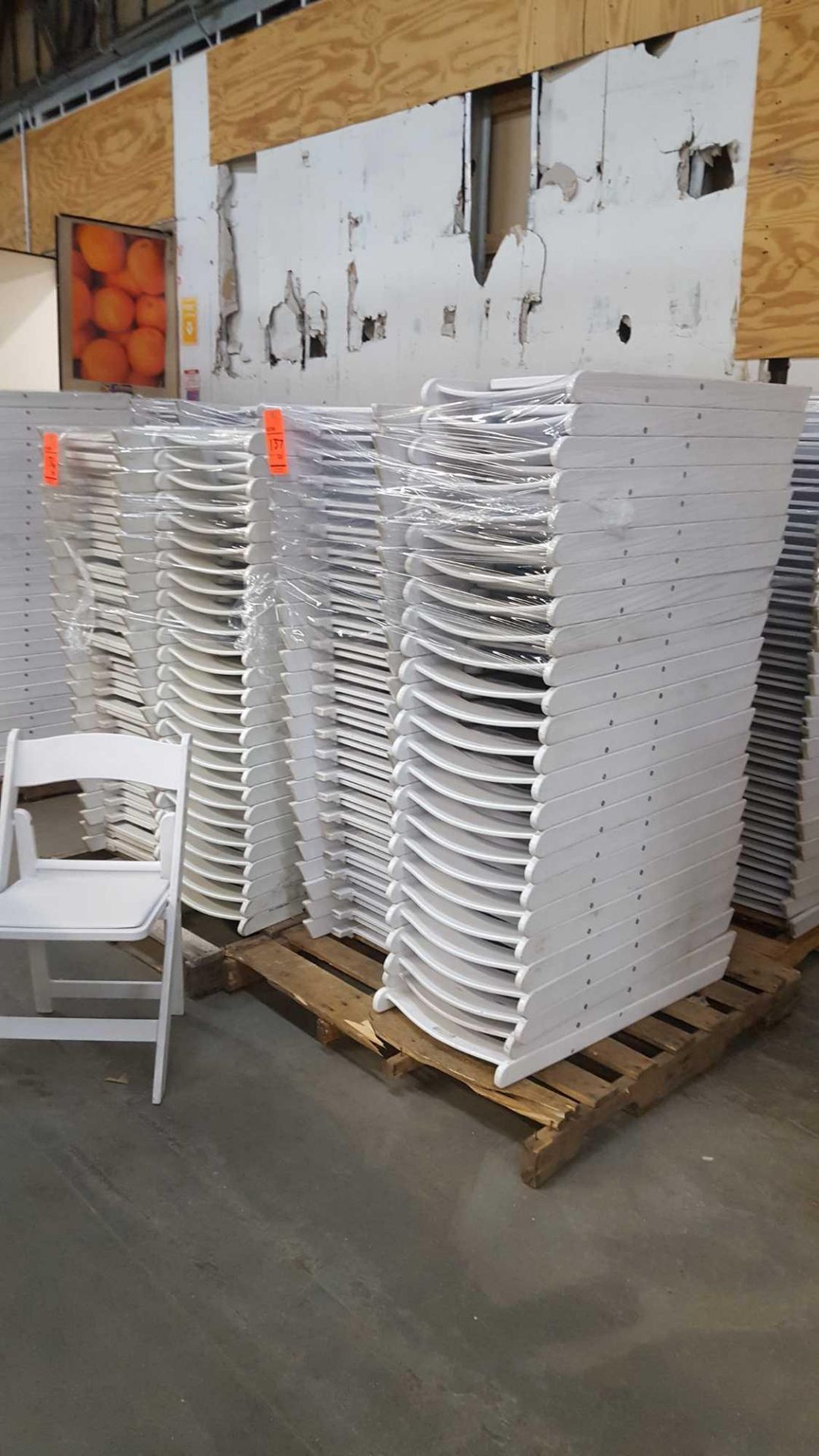 Lot of (50) assorted white resin folding chairs on a pallet