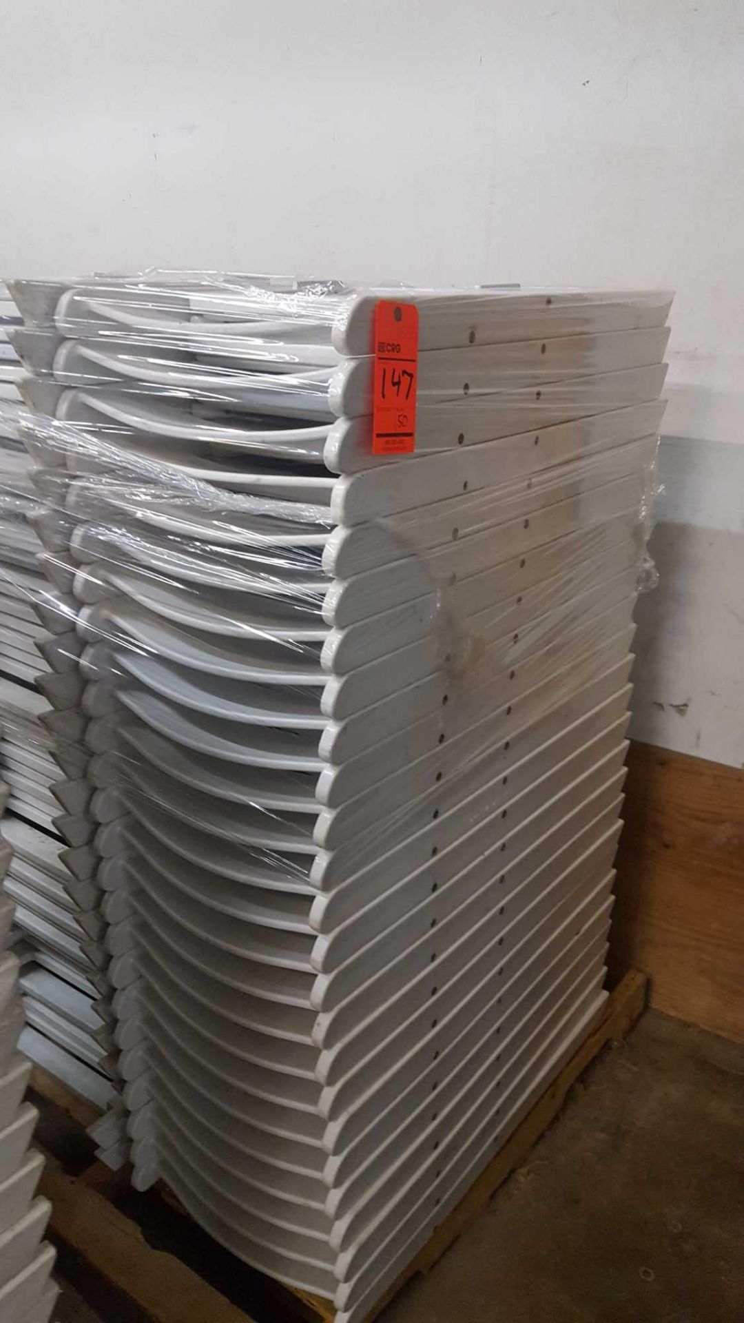 Lot of (50) assorted white resin folding chairs on a pallet