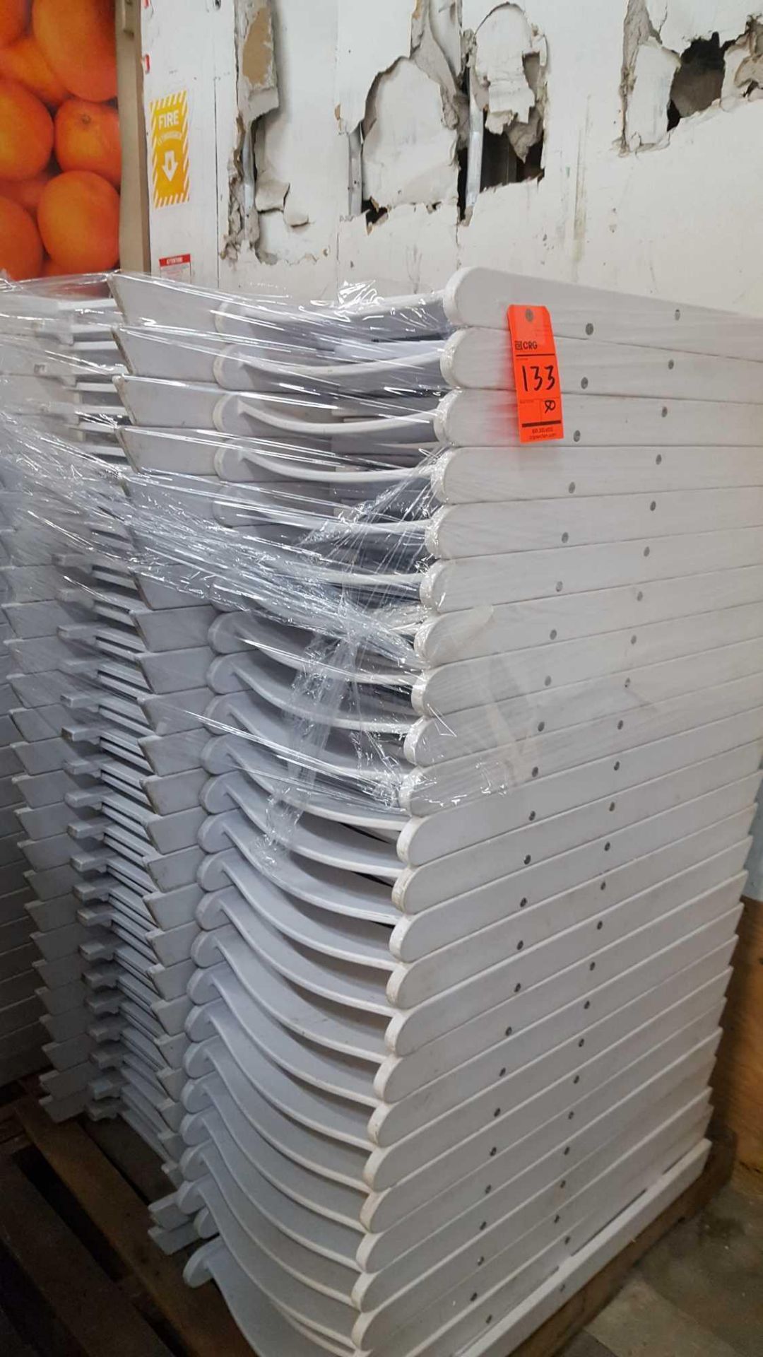 Lot of white folding resin chairs on a pallet