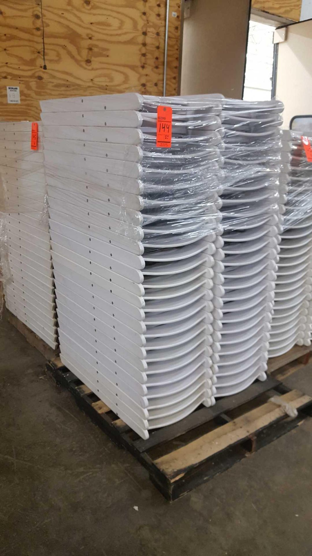 Lot of (50) assorted white resin folding chairs on a pallet